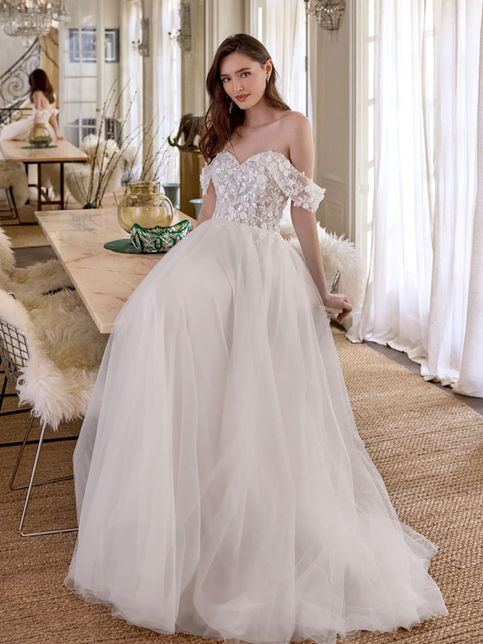 Abito da sposa linea A in tulle con scollo a cuore off shoulder, corpetto trasparente con pizzo ricamato e applicazioni floreali 3D, gonna ampia con strascico sweep