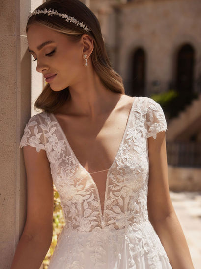 Abito da sposa in chiffon e pizzo con scollo a V e delicate manichette a coppa.