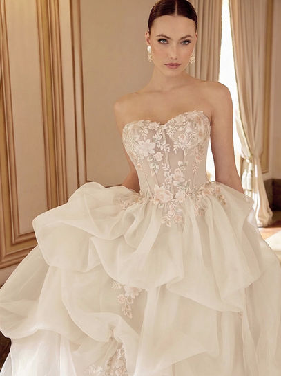 Abito da sposa principessa in organza con gonna a balze, scollatura a cuore e applicazioni in pizzo rosa e verde su tulle e rete