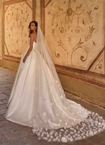 Abito da sposa principessa in raso Alberto Palatchi 2027 con bustier drappeggiato scollo a barchetta schiena scoperta e velo in tulle con applicazioni floreali 3D.