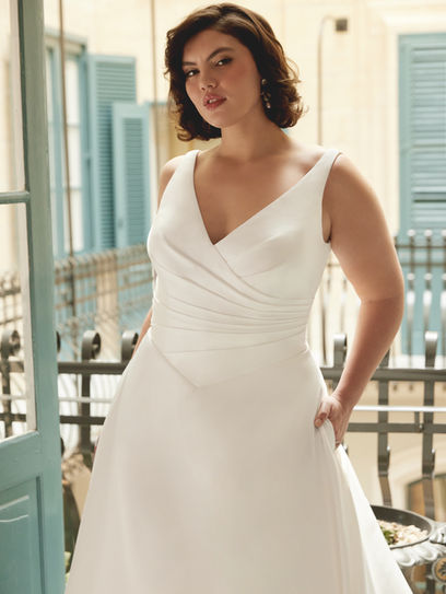 Abito da sposa principessa in mikado con scollo a V, corpino con vita basca plissettata e gonna ampia con tasche nascoste e strascico lungo.