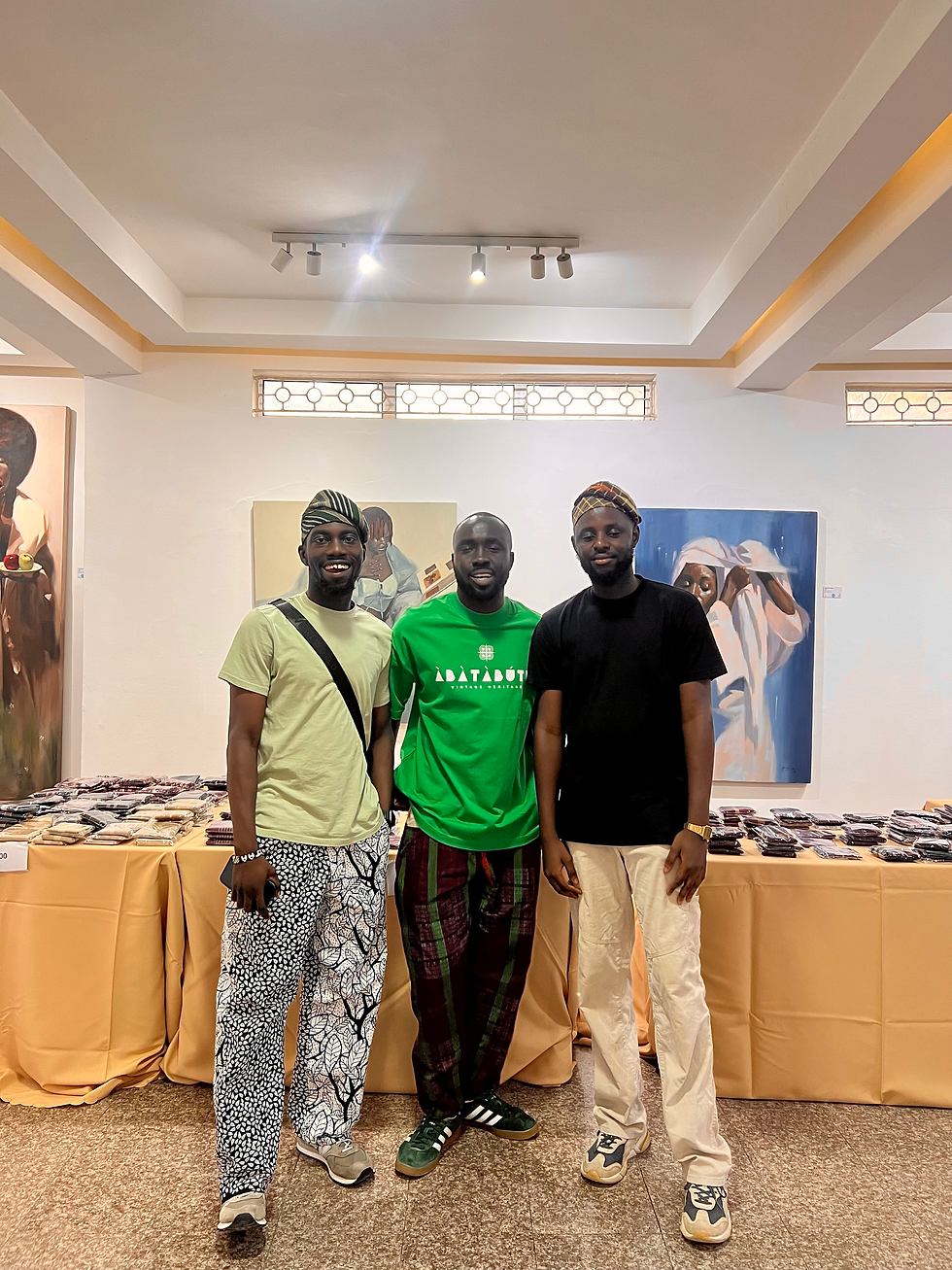 Credit: Photo by Mydrim Gallery - Young Nigerians styling fìlà with urban wear in a Lagos art gallery — a meeting of heritage and modernity.