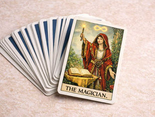 Carta dei Tarocchi “The Magician” con una figura femminile in abito rosso che tiene una candela accesa — simbolo dell’Archetipo della Maga, trasformazione e coscienza liminale.