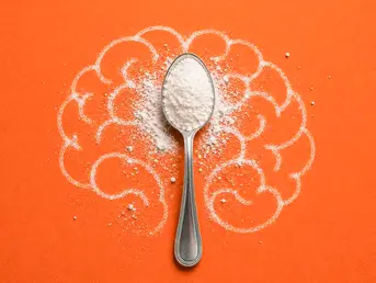 Spoon filled with creatine powder placed on a stylized brain illustration, symbolizing the connection between creatine, brain energy, physical performance, and psychosomatics.