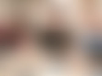 Three adults laughing while shaping clay together at a pottery wheel, expressing creative leisure in a playful and relaxed atmosphere.