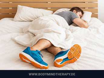 Person schläft im Bett mit Sportschuhen – Symbolbild für die Verbindung zwischen Sport und Schlaf.