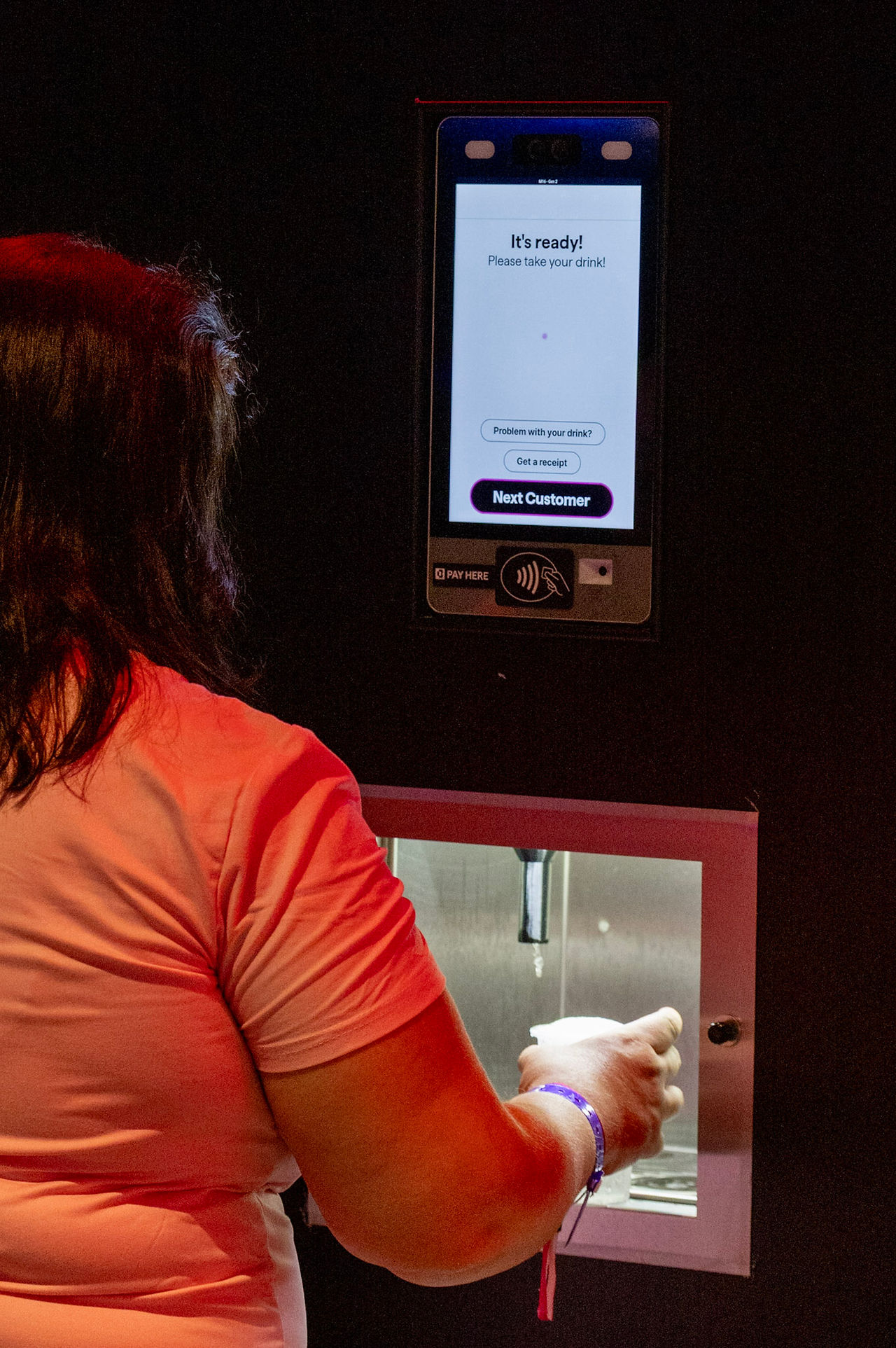 Person using self-service drinks machine