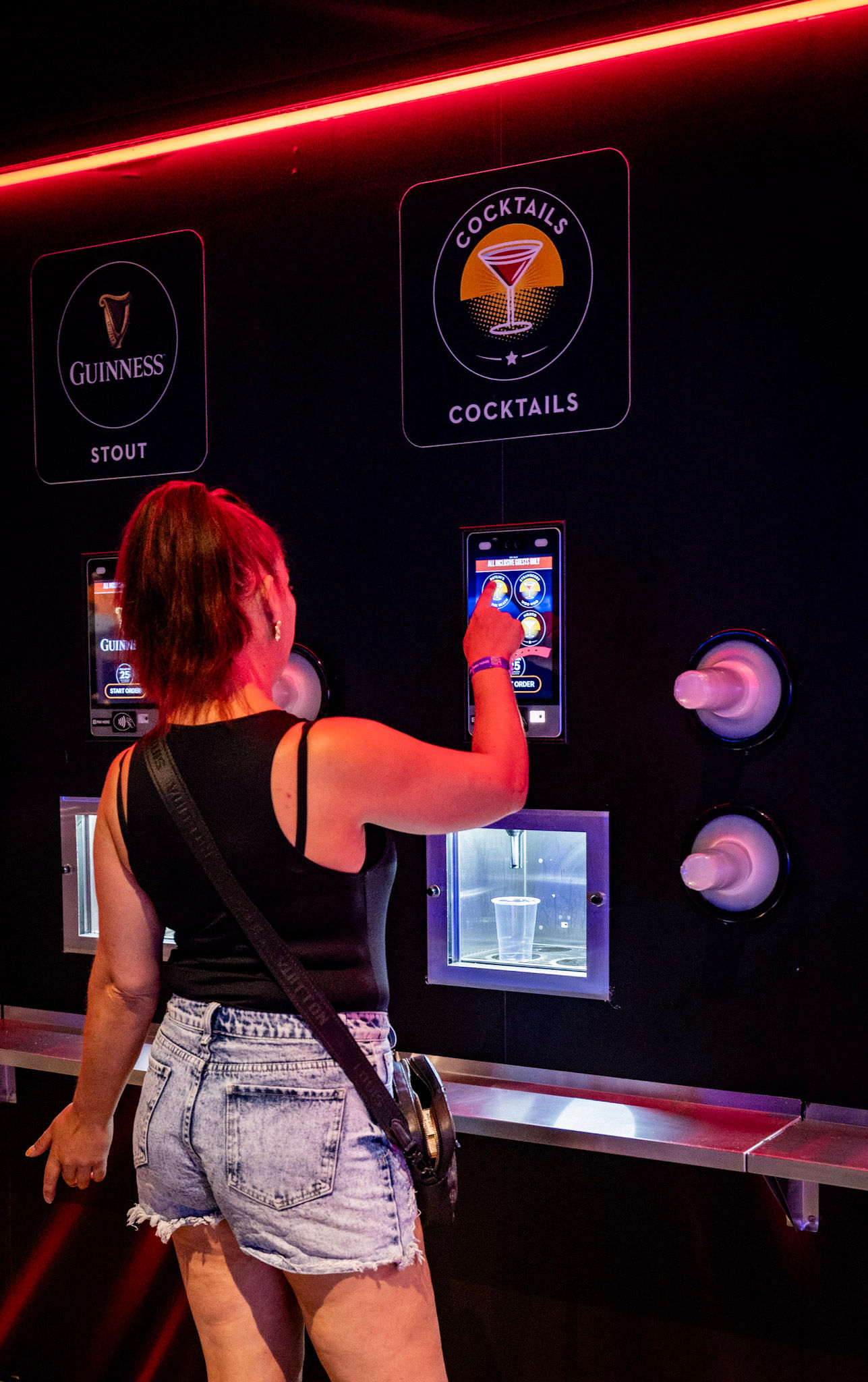 Person using self-service drinks machine