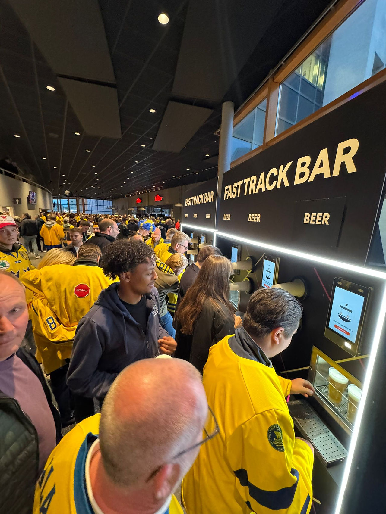 People queue art venue bar with swedish ice hockey shirts on