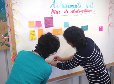 Two women put post its on a board