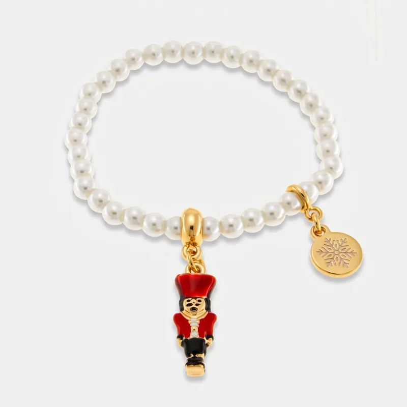 Bracciale BySimon con sfere chiare, schiaccianoci rosso pendente e medaglietta dorata con fiocco di neve.