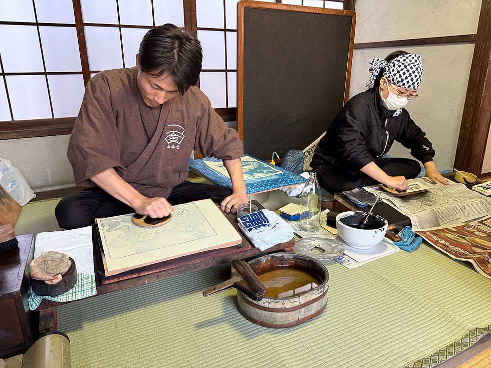 二人の摺師さんの実演風景。畳に座って作業する。