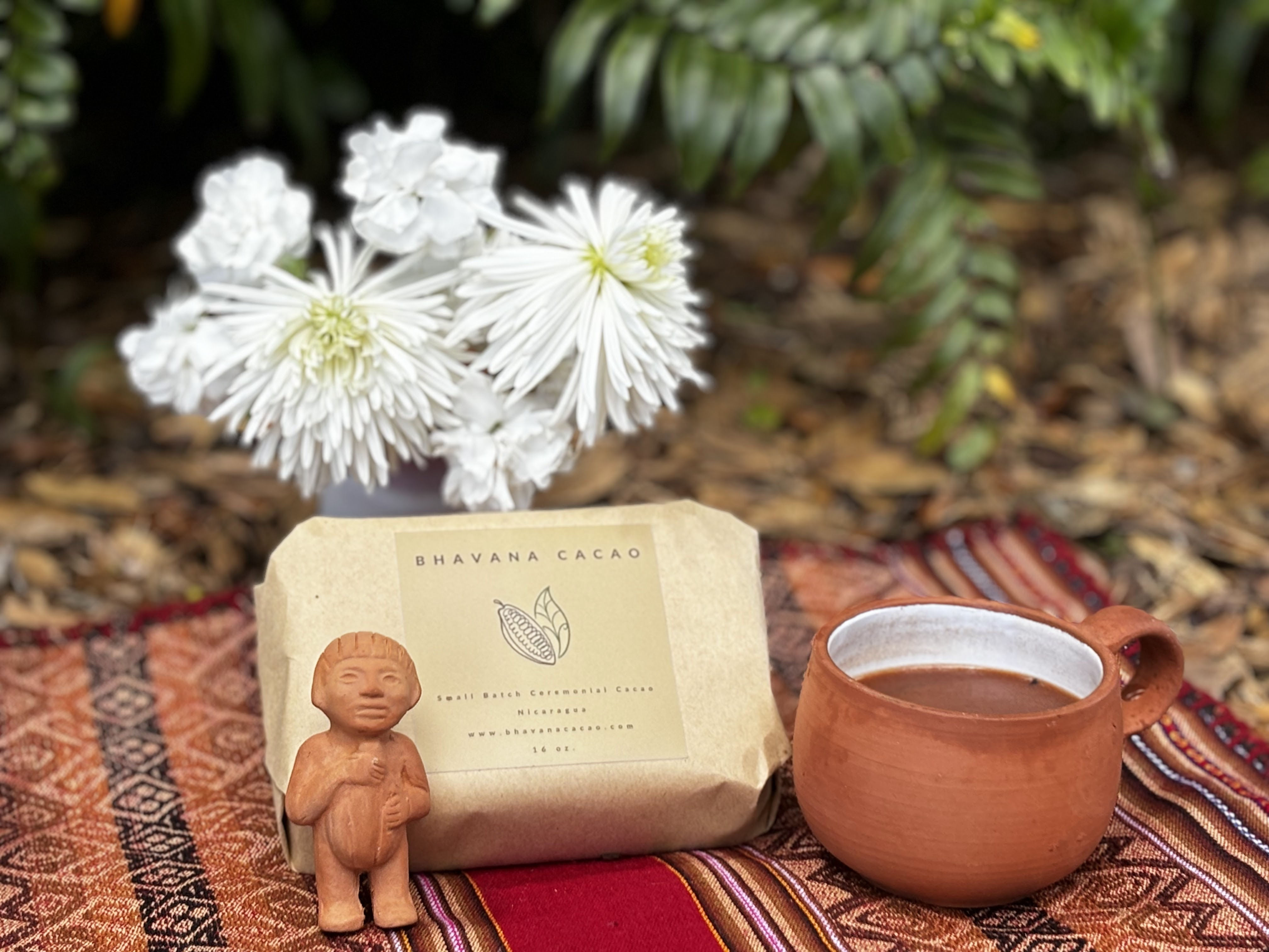 Cacao Paste, white flowers, cup of cacao, small statue.