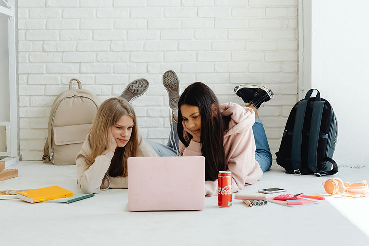 Two teenaged girls on the computer during the COVID pandemic.