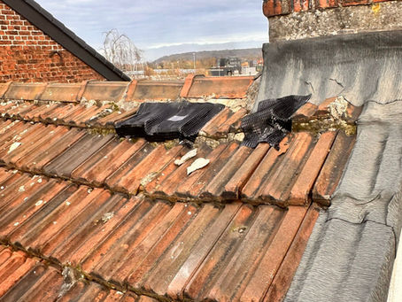 Stormschade aan dak met verschoven dakpannen na hevige wind