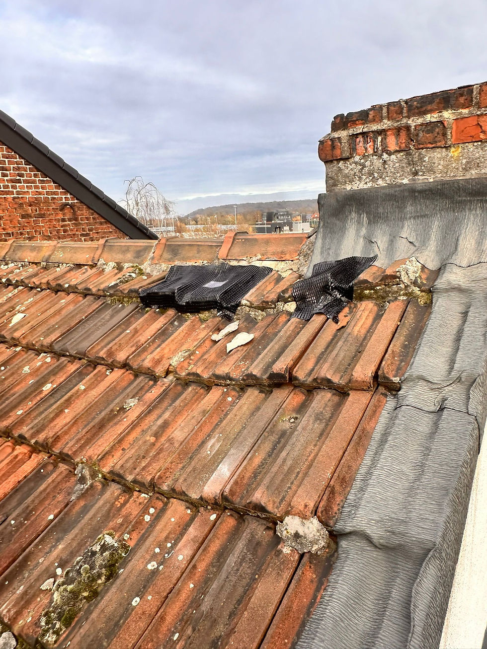 Stormschade aan dak met verschoven dakpannen na hevige wind