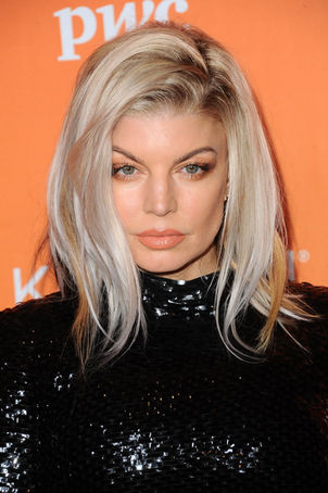 Fergie poses on the TrevorLIVE red carpet, wearing a sleek black sequined gown.