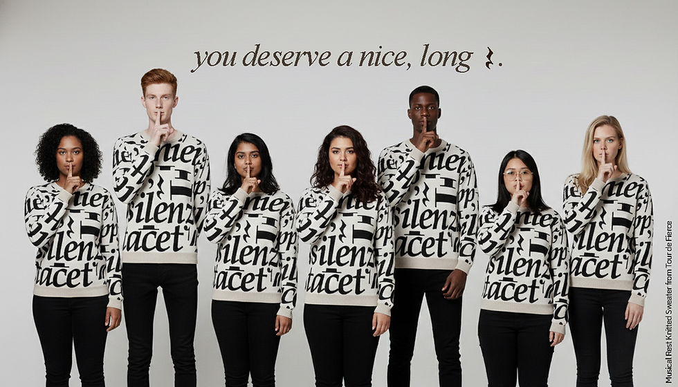 seven people stand shoulder-to-shoulder holding their index fingers to their mouths like shh, they all wear the same sweater with printed musical rests on them. copy says, "you deserve a nice long rest"