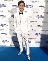 Photo of me (Joseph Stanek) attending Andrea Bocelli’s gala in Italy, wearing a white suit and a blue bow tie.