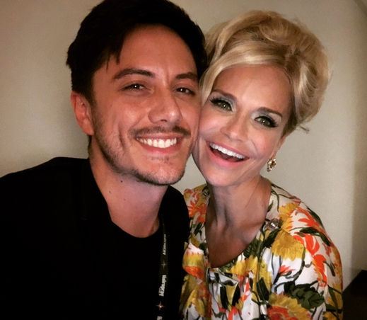 Kristin Chenoweth in a glamorous retro costume poses with Joseph Stanek during a commercial break in NBC’s Hairspray Live!.