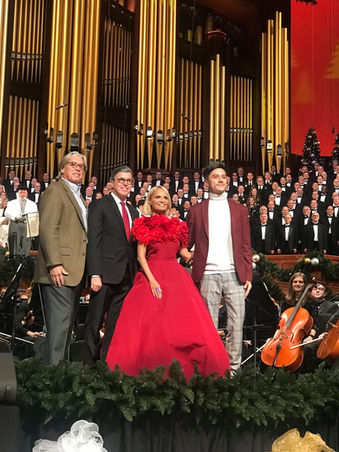 Kristin Chenoweth in a red couture gown performing with the Tabernacle Choir and Orchestra for "Angels Among Us" Christmas concert. Pictured with Producer Joseph Stanek on stage,