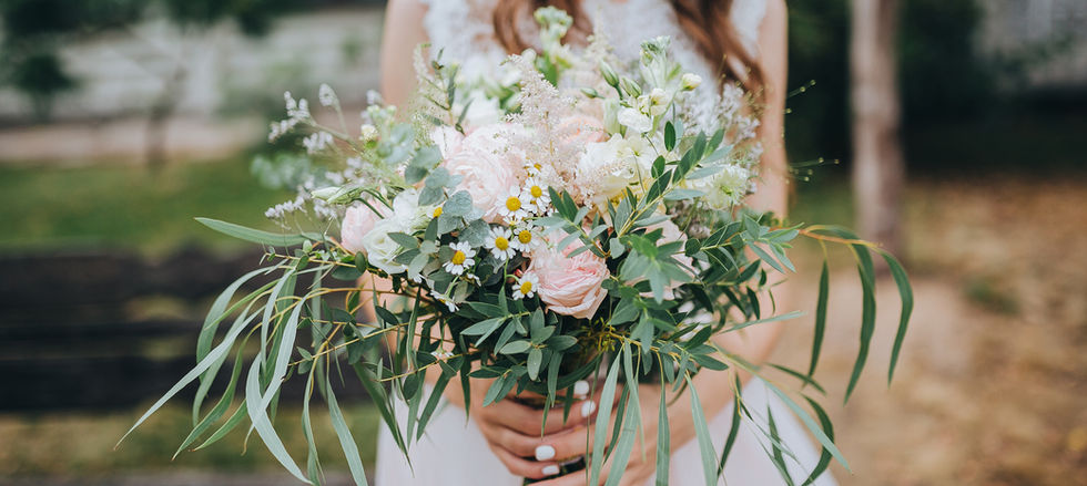 Loose, country garden style bridal bouquet in natural tones and soft seasonal flowers and flowing greenery in an unstructured, romantic design.