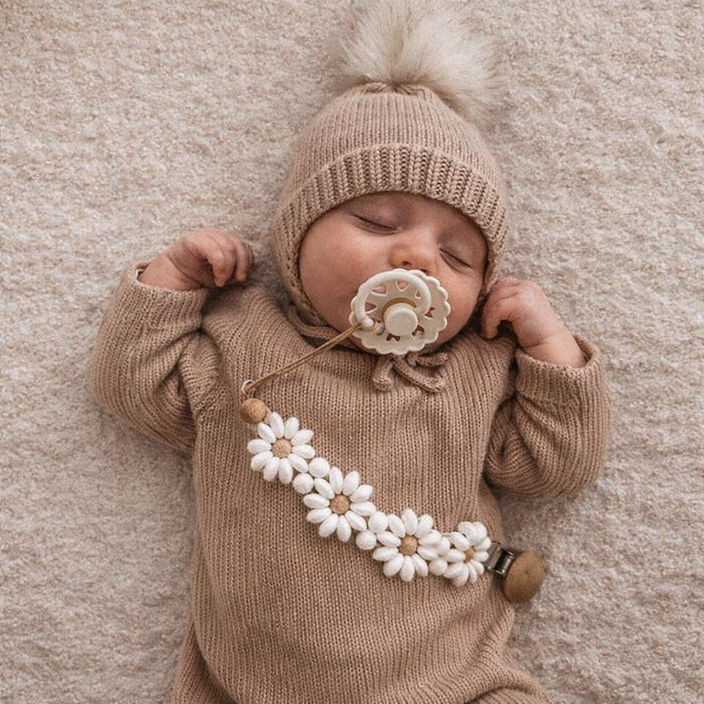 Bébé endormi avec une attache-tétine fleur faite à la main de la marque Mes Premières Mailles