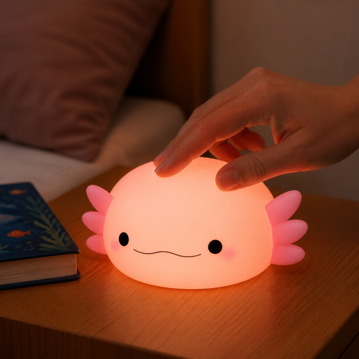 Close view of a hand gently pressing the silicone axolotl night light