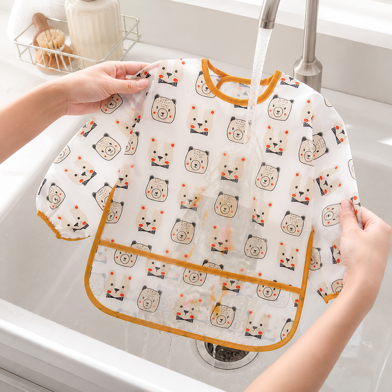 Parent rinsing the white bear-print long-sleeved smock after use