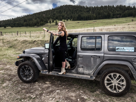 "Spotless Jeep from Missoula Adventure Rentals parked at a Montana trailhead with mountain views"
