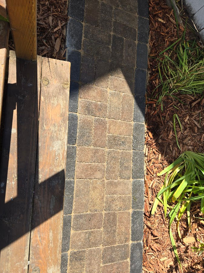 Garden hardscaping in Calgary showing a Roman paver stone pathway installed through a landscaped yard.