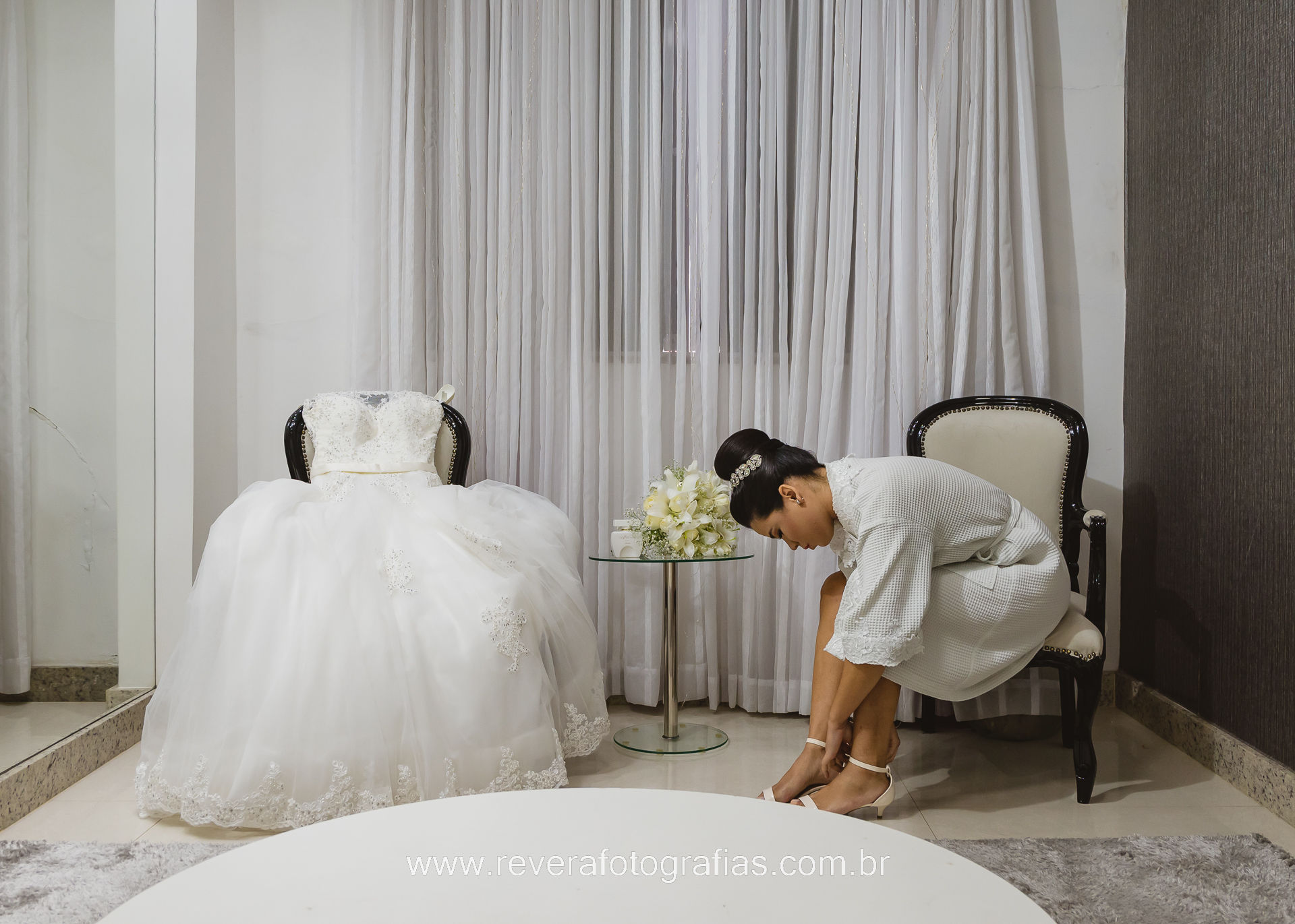 reverá fotografias: fotografia de fotógrafa profissional de making of de casamento intimista de dia no Haiti Noivas e Beauté retrato de noiva colocando sapato e vestindo em cima da poltrona ao lado em aracaju sergipe