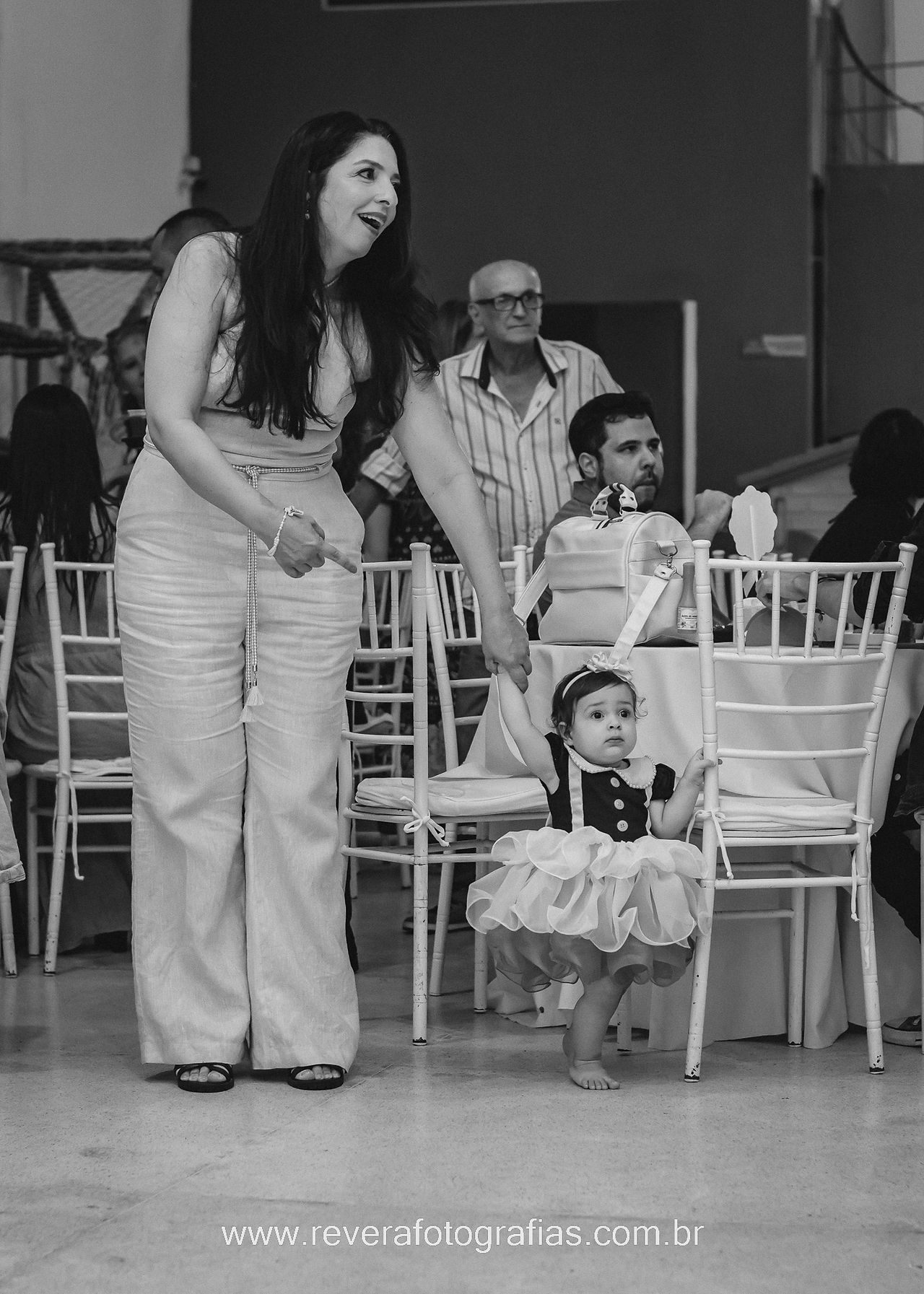 menina segura na mão da avó durante aniversário de 1 ano