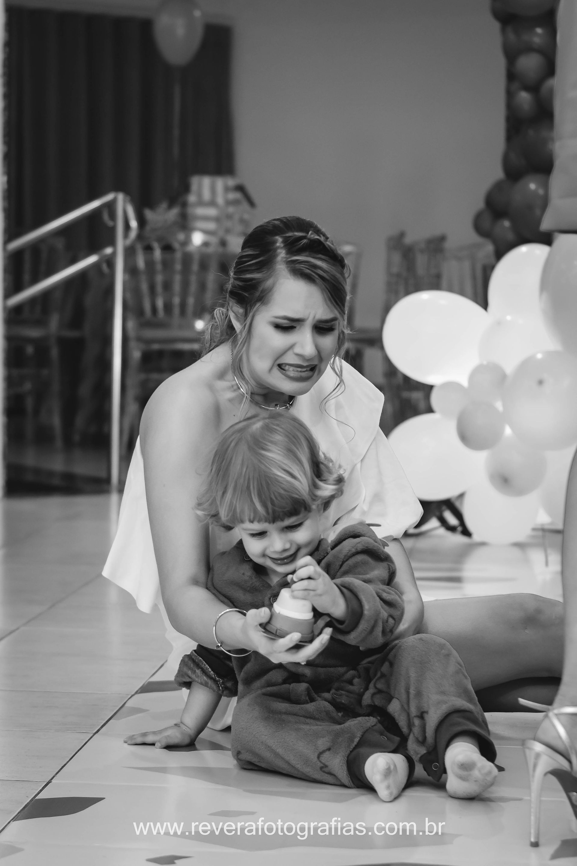 fotografia de mãe segurando menino enquanto ele brinca com decoração em festa de aniversário infantil em aracaju salão la fiesta