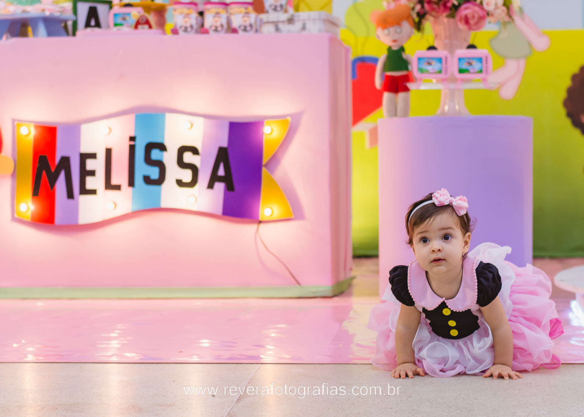 bebê com vestido do bita ao lado de placa iluminada com seu nome em festa de aniversário infantil