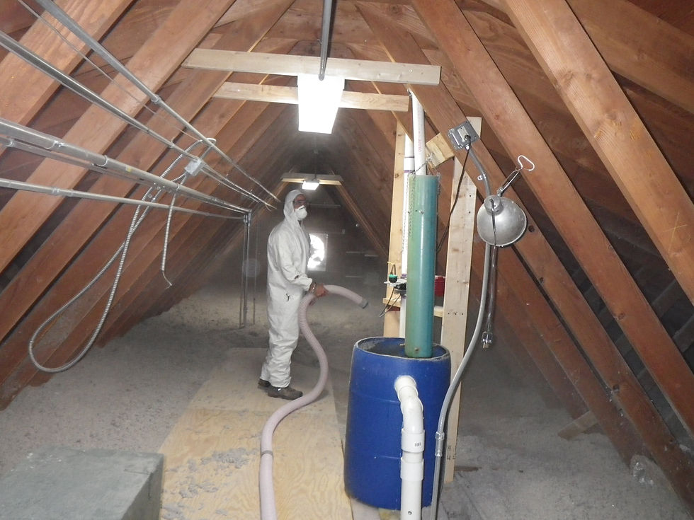 Une personne en combinaison souffle de l’isolant dans un comble technique.