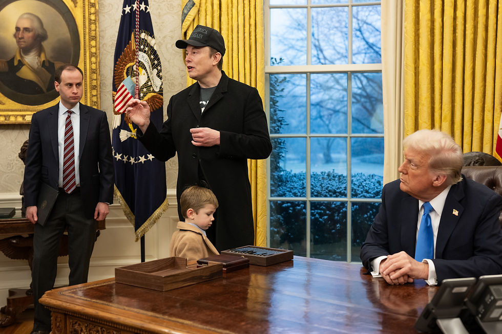 Photo d’archives d’Elon Musk debout, portant une casquette, auprès de Donald Trump assis au Bureau ovale; un enfant se tient près du bureau.