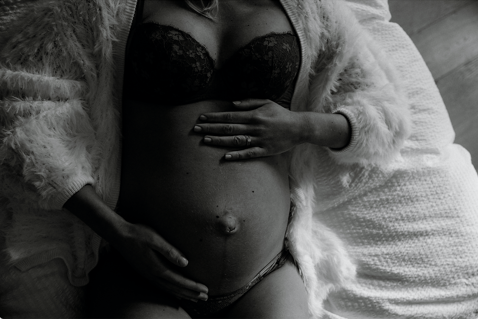 Black and white image of pregnant mother on bed