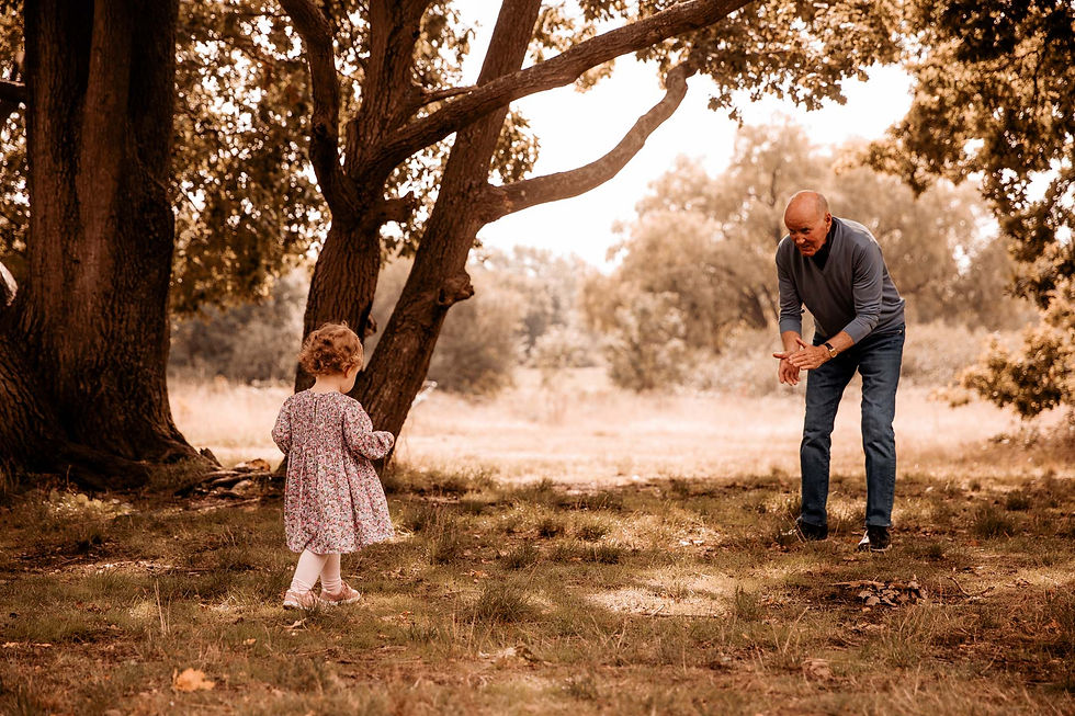 Little girl running towards her Grandad in parkland