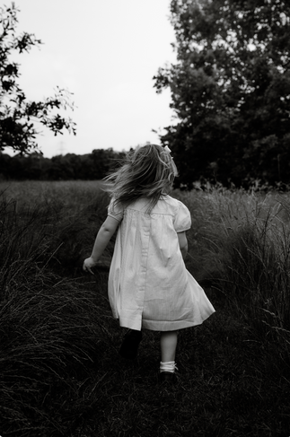 Black and white photograph of a child running down a path