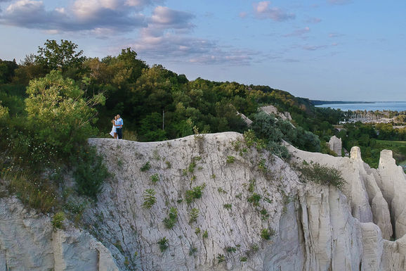 Couple standing on the dramatic Scarborough Bluffs overlooking Lake Ontario, expertly photographed by a Scarborough wedding photographer