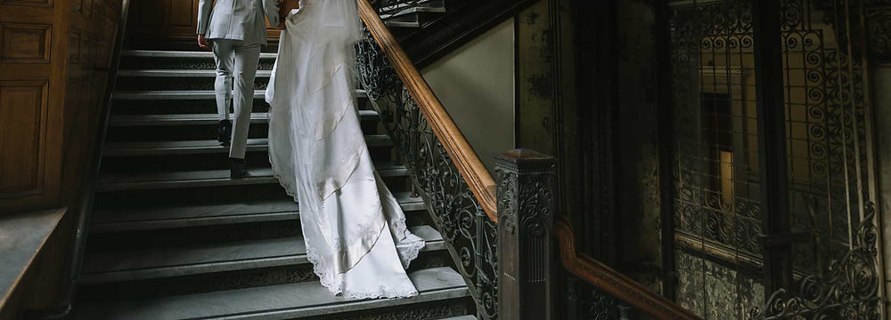 Bride and groom on a historic indoor stone and iron staircase for a fine art Toronto wedding portrait