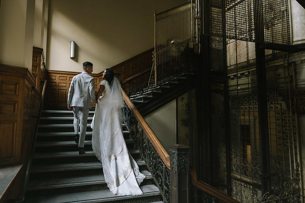 Couple ascending stairs in vintage building for cinematic wedding photography in Toronto.