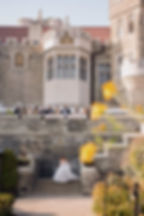 bride walking down casa loma staircase for first look while wedding party watches from above on the terrace