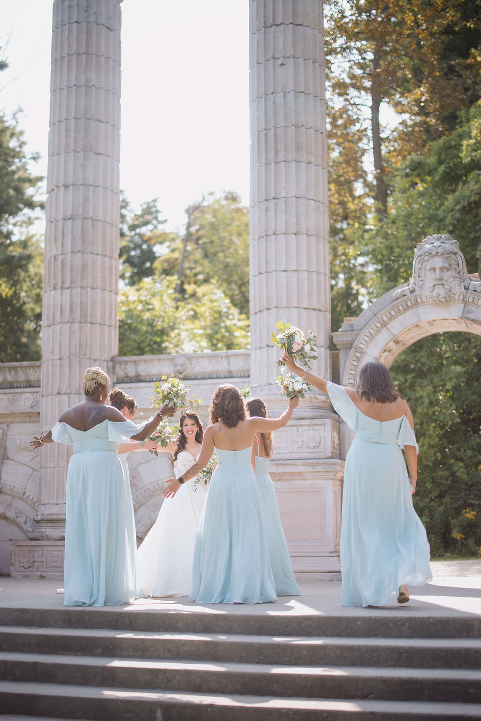 Bridesmaids celebrating at a wedding near classical columns in Scarborough – joyful moment captured by a Scarborough wedding photographer