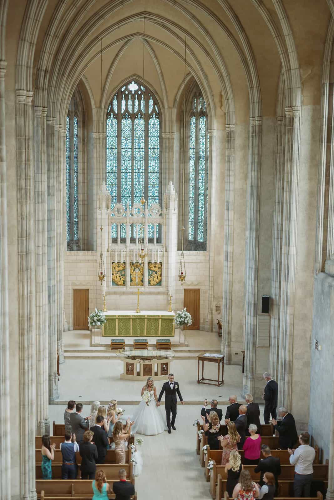 Elevated wide view of a beautiful wedding ceremony inside the historic, gothic architecture of Trinity Chapel in Toronto.