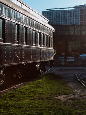  Vintage black passenger railcar at Roundhouse Park, a unique backdrop for Steam Whistle wedding portraits.
