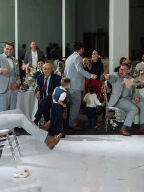  High-energy candid of a wedding guest celebrating on the white dance floor during a lively Toronto reception.