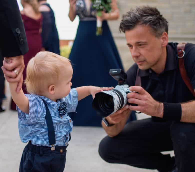 Lucas T showing boy his camera at a wedding in Toronto
