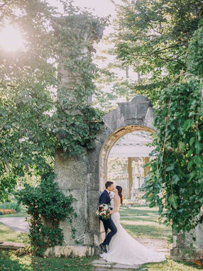 Intimate couple portrait at a vine-covered stone archway in a Toronto heritage garden